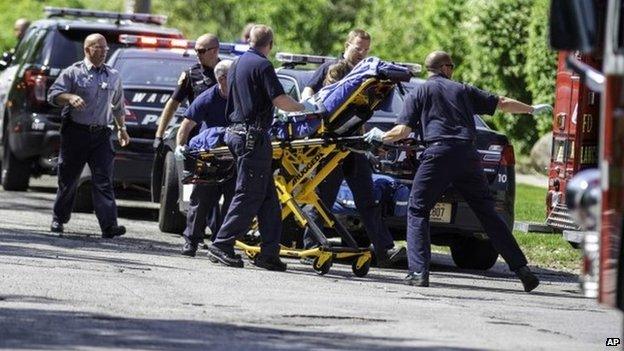 Rescue workers take a stabbing victim to the ambulance in Waukesha, Wisconsin 31 May 2014