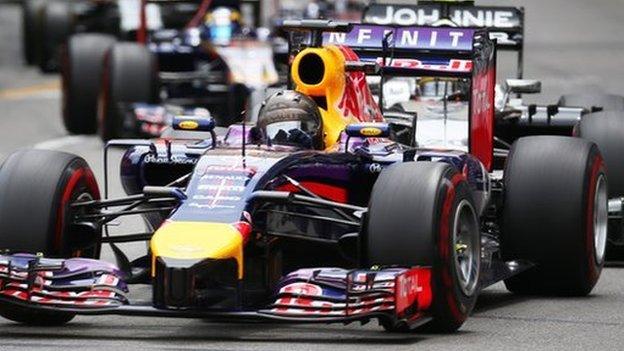 a row of formula one cars driving on the track