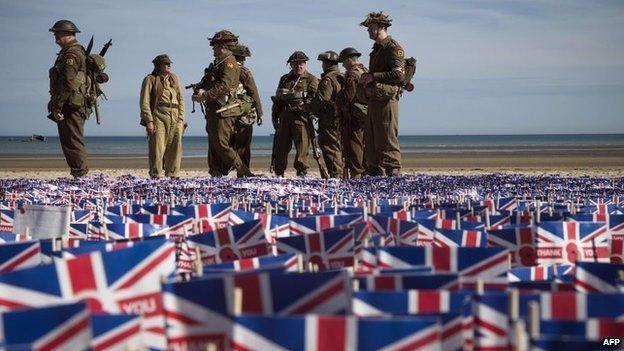 People in military uniforms on Sword Beach