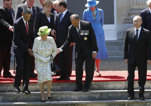 Russian President Vladimir Putin stands to the right as US President Barack Obama, left, and New Zealand's Governor-General Jerry Mateparae guide Britain's Queen Elizabeth to her position for a group photo during the commemorations for the 70th anniversary of the D-Day landings, in Benouville in Normandy, France, 6 June 2014