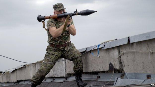 A pro-Russian fighter prepares to launch a rocket propelled grenade during clashes near Luhansk, eastern Ukraine. Photo: 2 June 2014