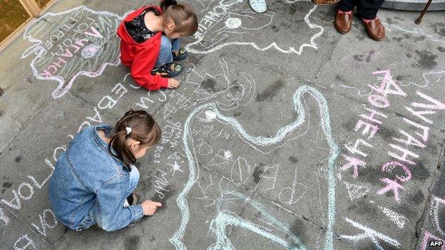 Children, refugees from Crimea and from eastern Ukrainian regions, draw symbolic maps depicting their regions and cities, on the sidewalk at the entrance of Ukrainian parliament in Kiev during a rally on 5 June