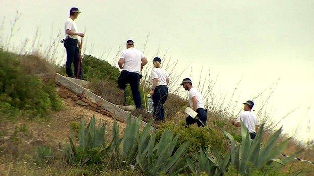 A team of police searching scrubland