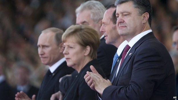 Ukraine's President-elect Petro Poroshenko (R), German Chancellor Angela Merkel (C) and Russian President Vladimir Putin (L) applaud during the commemoration of the 70th anniversary of D-Day in Ouistreham, western France on 6 June 2014