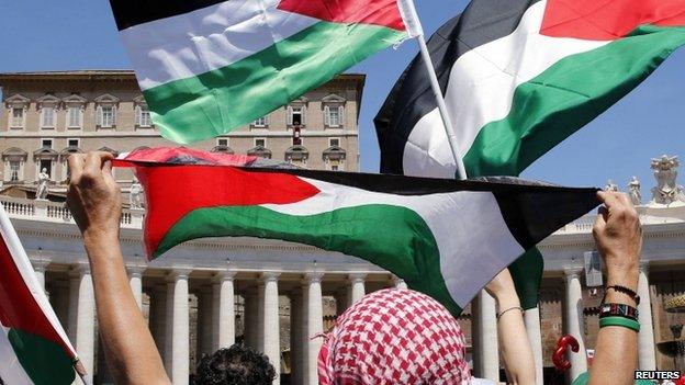 Palestinians wave flags as Pope Francis delivers his Regina Coeli prayer from the window of the Apostolic Palace in Saint Peter's Square on Sunday (8 June 2014)