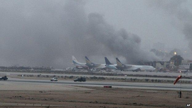 Smoke rises above the Jinnah International Airport where security forces continue to battle militants Monday, June 9, 2014, in Karachi, Pakistan.