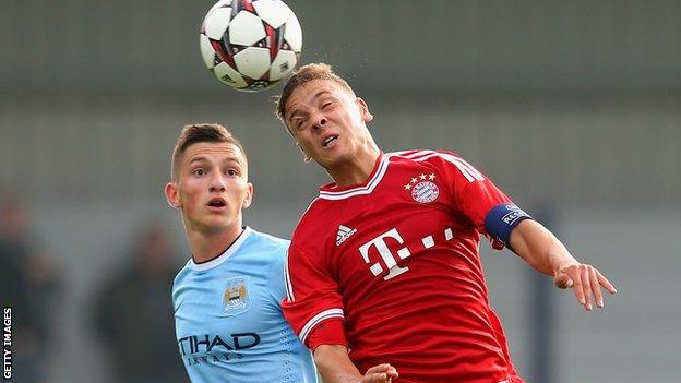 Manchester City's Sinan Bytyqi heads the ball ahead of Bayern Munich's Angelos Oikonomou