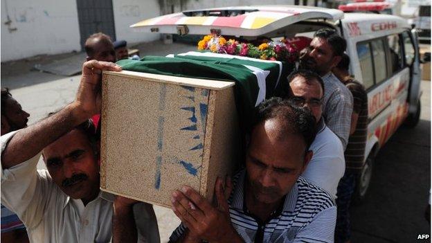 Pakistani Airport Security Force personnel carry the body of a dead colleague in Karachi (9 June 2014)