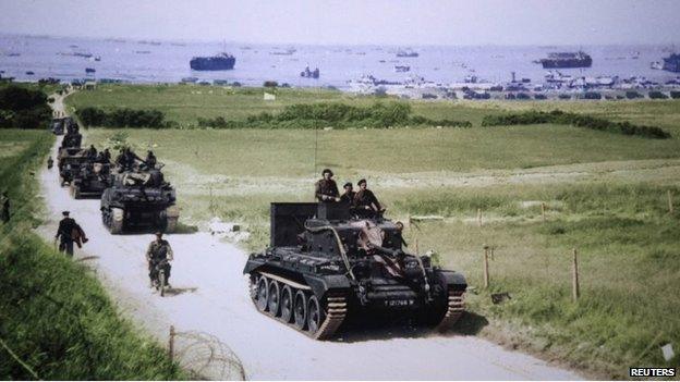 A Cromwell tank leads a British Army column from the 4th County of London Yeomanry, 7th Armoured Division, heading inland from Gold Beach on 6 June 1944