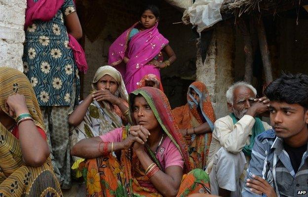 Residents of a village, where the bodies of two gang-rape victims were found hanging from a tree originate from, look on in Karta Shahadatgunj in Badaun