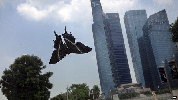 A moth rests on a glass door leading mall goers towards the central business district in Singapore on Tuesday, 15 April, 2014
