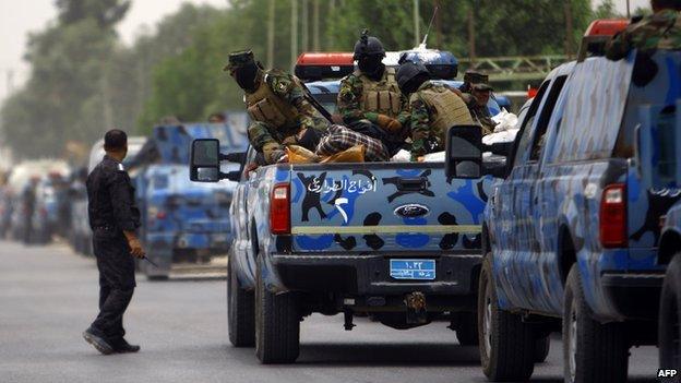 Iraqi soldiers gather as their unit is shipped north from the central Shiite Muslim shrine city of Najaf to Mosul following the increased violence, on 8 June 2014.