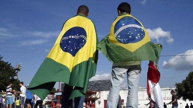 People wearing Brazilian flags arrive at the Santa Cruz Stadium in Ribeirao Prato on 10 June 2014