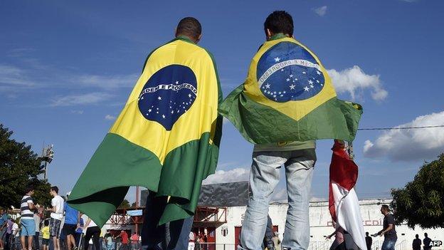 People wearing Brazilian flags arrive at the Santa Cruz Stadium in Ribeirao Prato on 10 June 2014