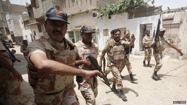 Paramilitary soldiers search in a neighbourhood after a gunfire attack on a security academy run by the Airports Security Force (ASF) in Karachi, 10 June 2014