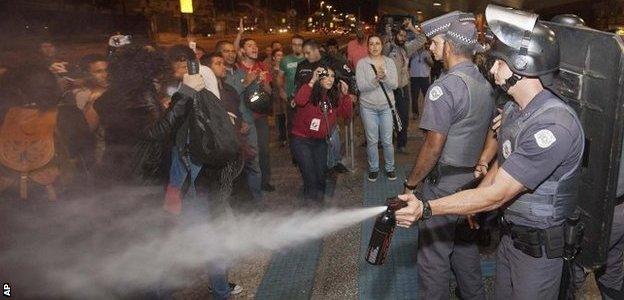 A police officer pepper sprays strikers and protesters during a clash with riot police in front of the Ana Rosa metro station, in an ongoing subway strike by operators in Sao Paulo, Brazil, on 9 June 9, 2014