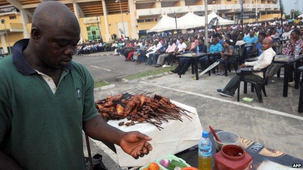A man prepares barbecue popularly known as Suya for fans watching Nigeria's match against Ethiopia at a public viewing centre in Lagos - 29 January 2013