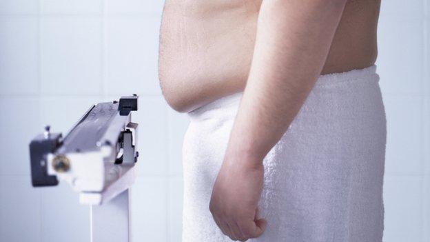 An overweight man on scales - file pic