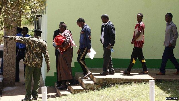 Suspected Somali illegal migrants and refugees arrested in a police swoop arrive at a holding station in Kenya's capital, Nairobi, 7 April 2014