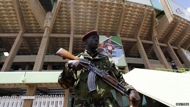 A policeman stands guard as suspected Somali illegal migrants and refugees arrested in a swoop are processed for deportation at a holding station in Kenya's capital, Nairobi - 9 April 2014