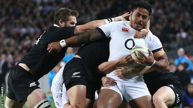 Manu Tuilagi of England is tackled by the All Black defence