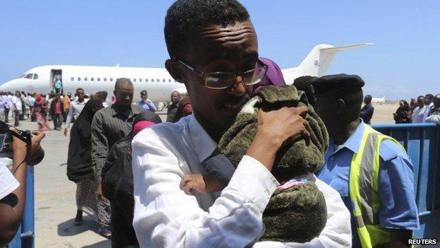 A Somali man and his child deported from Kenya arrive at the airport in Somalia's capital, Mogadishu, 9 April 2014