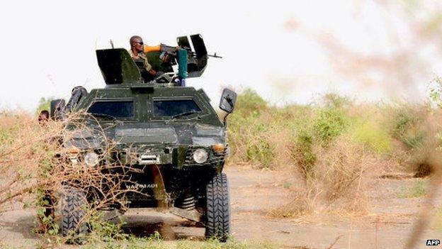 Nigerian soldiers patrol in the north of Borno state close to a Islamist extremist group Boko Haram former camp on 5 June 2013 near Maiduguri