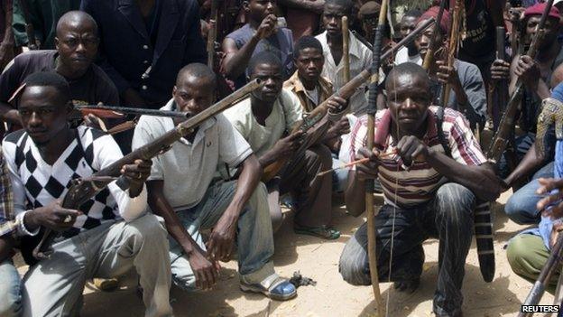 A vigilante group of traditional hunters pose for a picture at their camp in Maiduguri 21 May 2014