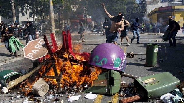 A man throws a rock towards riot police during a protest in Sao Paulo - 12 June 2014