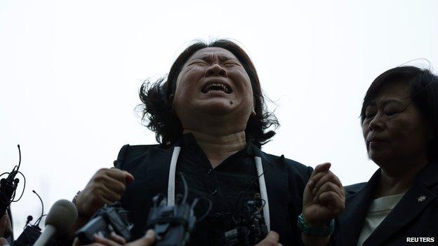 The mother of a victim onboard sunken ferry cries as she speaks to the media in front of a building in which crew members are detained, after attending a hearing at the local court in Gwangju on 10 June, 2014