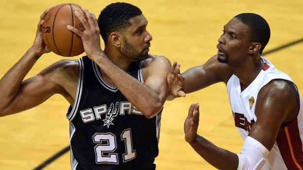 San Antonio's Tim Duncan (left) keeps the ball away from Miami's Chris Bosh