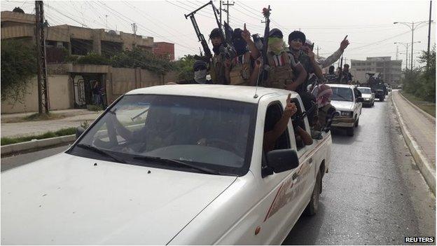 ISIS fighters celebrate on vehicles taken from Iraqi security forces, at a street in city of Mosul on 12 June