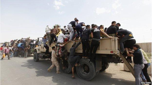 Volunteers board army trucks in Baghdad, on 13 June.