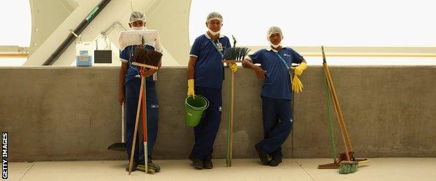 Workers take a break as they prepare the stadium at the Arena Amazonia in Manaus ahead of England's first game.