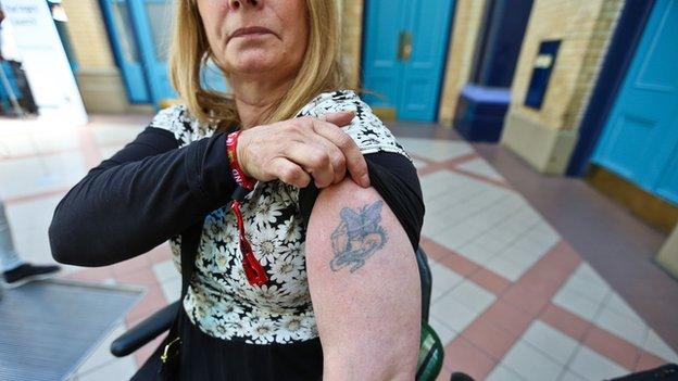 Rita, showing her butterfly tattoo