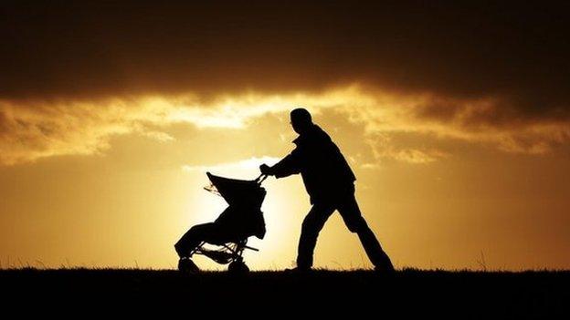 Father pushing buggy on Hampstead Heath in London