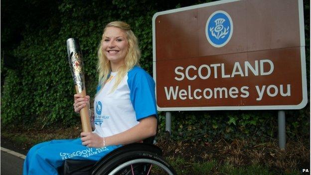 Batonbearer Samantha Kinghorn carrying the Queen"s Baton through Coldstream