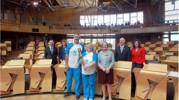 Gavin Hastings and batonbearer Lynne McNicoll with presiding officer Tricia Marwick in the Scottish Parlaiment chamber