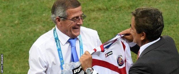 Costa Rica coach Jorge Luis Pinto offers Uruguay coach Oscar Tabarez a football shirt after the game