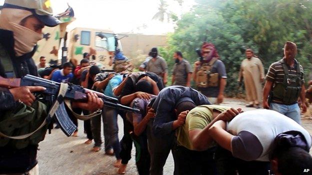 Picture apparently showing captured Iraqi soldiers in civilian clothes being led away by ISIS militants