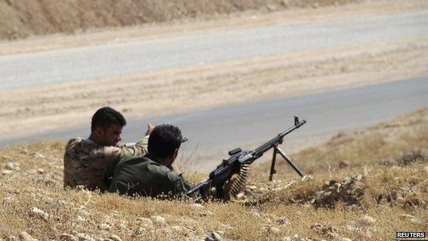 Members of the Kurdish security forces take position during clashes with Sunni militant group Islamic State of Iraq and the Levant