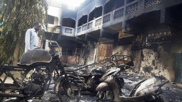 A man looks at destroyed vehicles in Mpeketoni. Photo: 16 June 2014