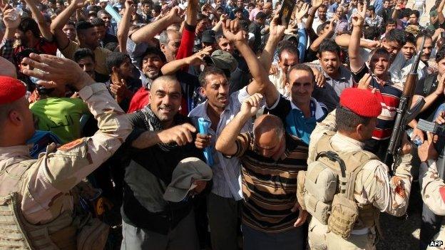 Iraqi men who volunteered to fight gather around buses in Baghdad, on June 16, 2014