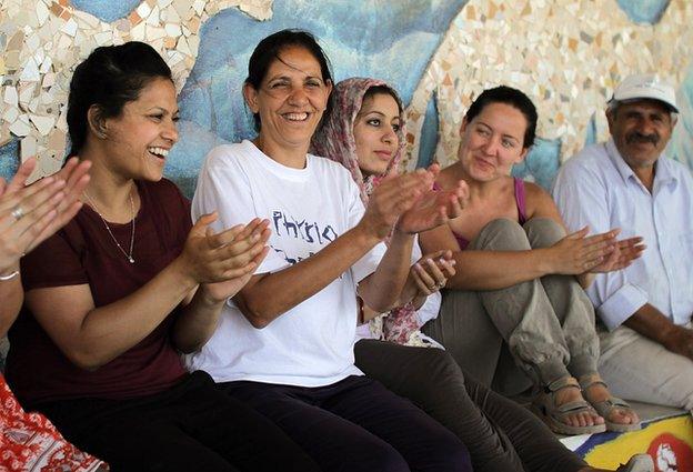 Amal Nassar singing with international volunteers at the Tent of Nations farm