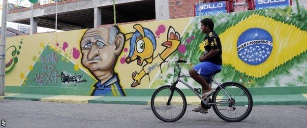 A cyclist passes a Brazil mural in Fortaleza