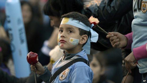 A fan of Uruguay's national soccer team eats a toffee apple as he watches the Brazil 2014 World Cup match between Costa Rica and Uruguay on 14 June, 2014