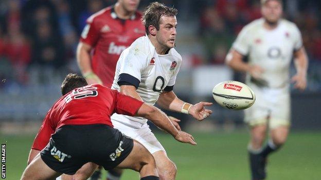 England fly-half Stephen Myler offloads under pressure against the Crusaders