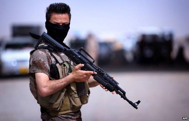 Iraqi Kurdish Peshmerga fighter at a camp set up for those fleeing the violence in Nineveh province (13 June 2014)