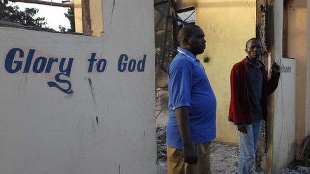 Residents of Kibaoni look at the ruins of the burnt down Breeze View Hotel after unidentified gunmen attacked the coastal Kenyan town of Mpeketoni June 16, 2014.