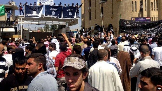 Islamic State of Iraq and the Levant supporters chant pro al-Qaeda slogans in front of the provincial government headquarters in Mosul, Iraq, Monday, June 16, 2014